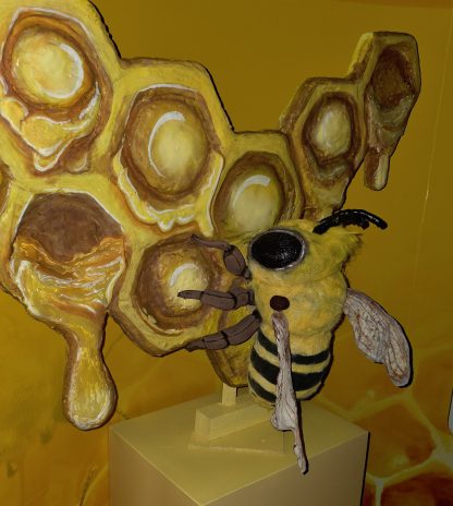 a crafted bee on a painted honeycomb